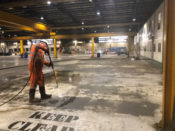 Pressure washing factory floor and removing oily washings